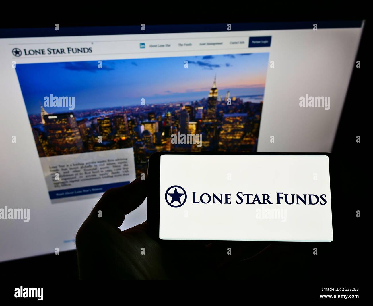 Person, die das Smartphone mit dem Logo der US-Investmentgesellschaft Lone Star Funds auf dem Bildschirm vor der Website hält. Konzentrieren Sie sich auf die Telefonanzeige. Stockfoto