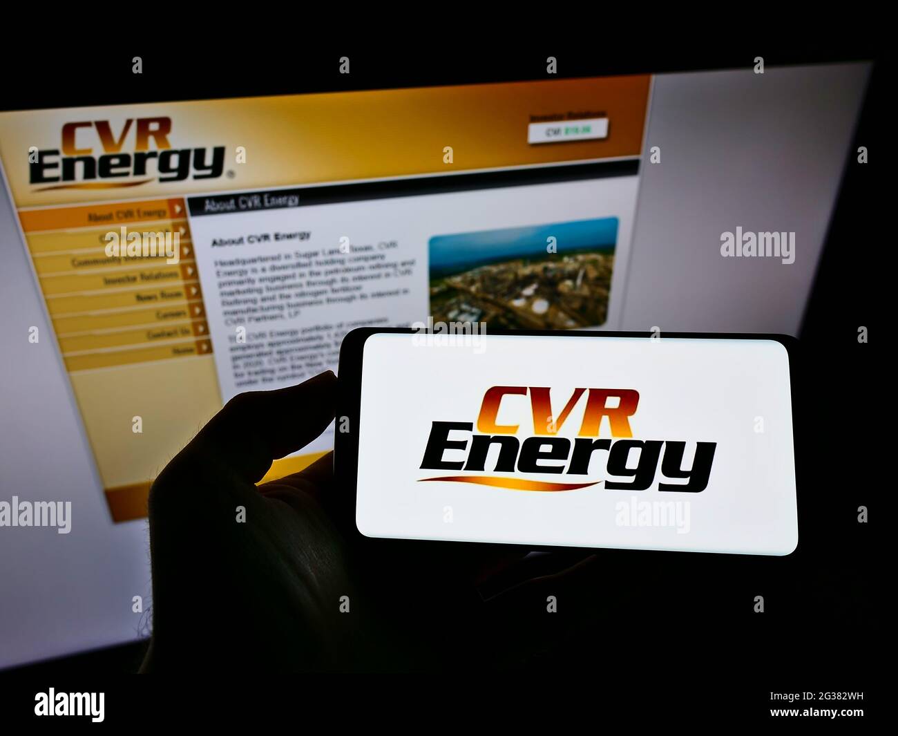 Person, die ein Mobiltelefon mit dem Logo des amerikanischen Mineralölunternehmens CVR Energy Inc. Auf dem Bildschirm vor der Unternehmenswebseite hält. Konzentrieren Sie sich auf die Telefonanzeige. Stockfoto