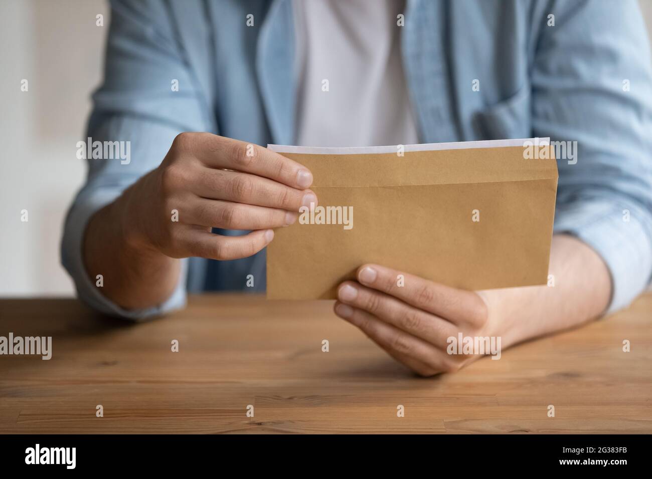Nahaufnahme des jungen Mannes, der geschäftliche Korrespondenz in Briefumschlägen erhält. Stockfoto
