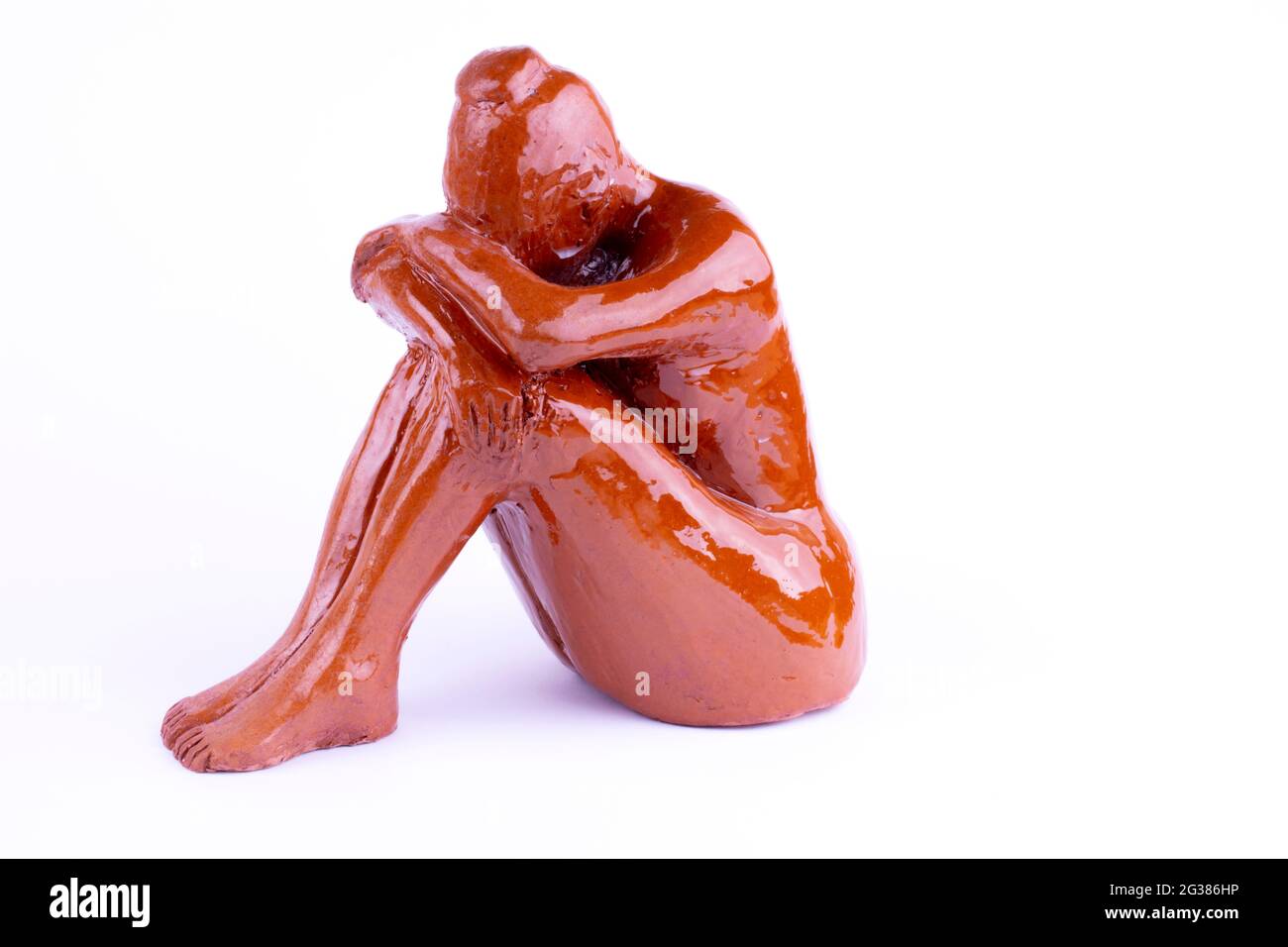 Keramikfigur Frau. Frau in Depressionen. Isoliert auf Weiß Stockfoto