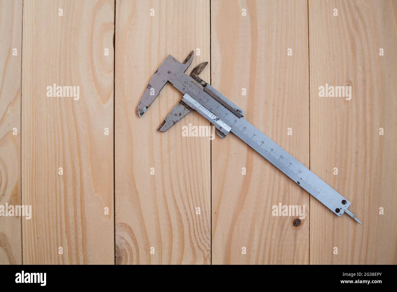 Messschieber auf hellem Holzhintergrund. Arbeitskonzept. Stockfoto