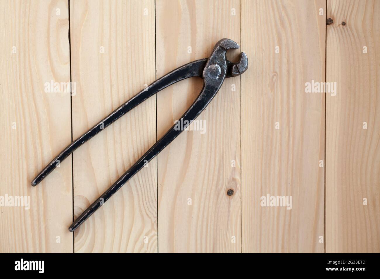 Zangen, Werkzeug zum Entfernen von Nägeln aus Holz. Vintage Metallzangen  auf einem hellen Holzhintergrund. Alte, offene, rostige Zange zum Entfernen  von na Stockfotografie - Alamy
