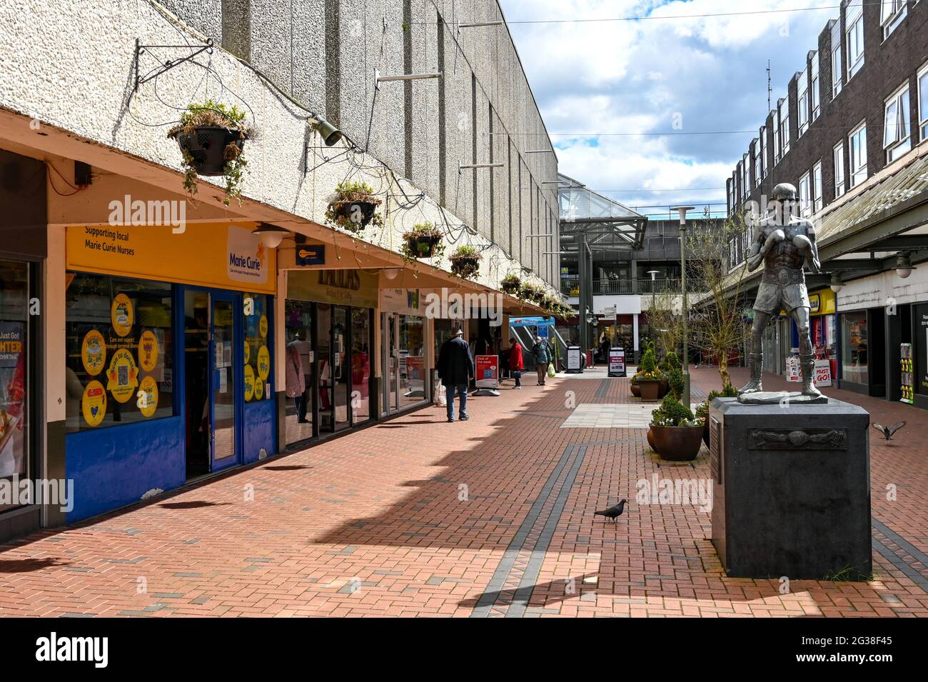 Merthyr Tydfil, Wales - Mai 2021: Geschäfte im Einkaufszentrum von St. Tydfil. Rechts ist eine Statue des Boxers Johnny Owen aus Merthyr. Stockfoto