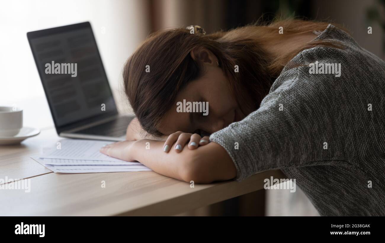 Nahaufnahme erschöpft unmotivierte junge Frau am Arbeitsplatz schlafen Stockfoto