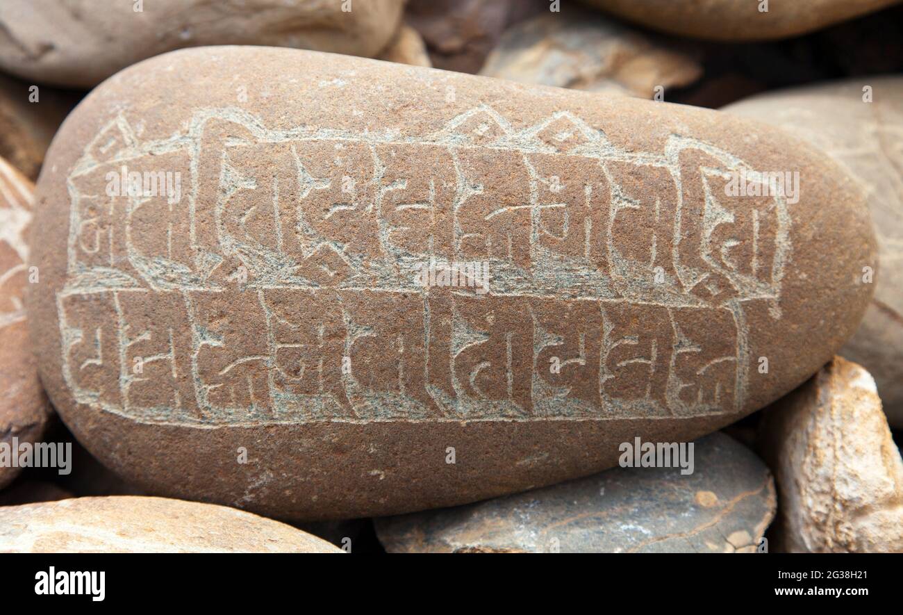 Mani Wand und Steine mit buddhistischen Symbolen Stockfoto