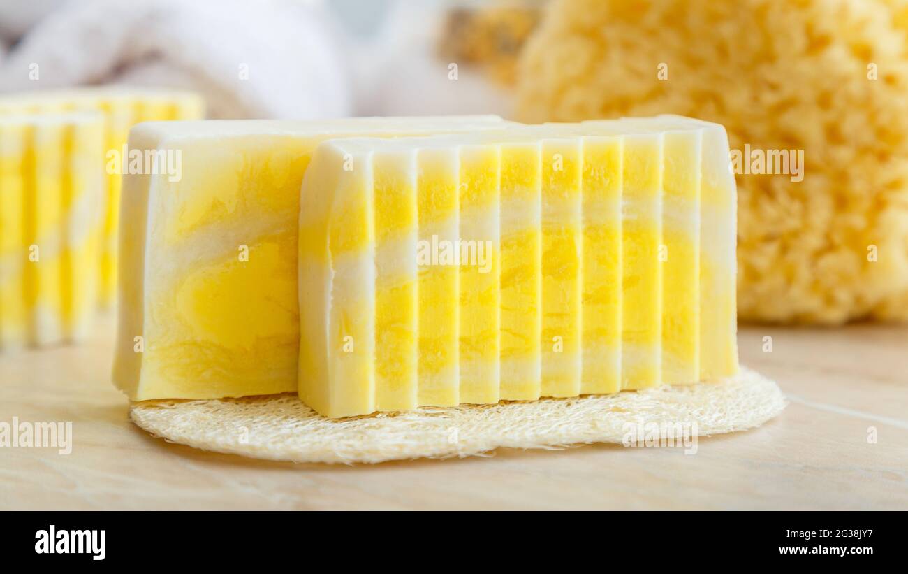 Natürliche handgemachte Seifenstücke. Duftende Seifenstücke für Spa-Behandlungen mit Loofah-Schwamm, natürlichem Seegrubber. Toilettenartikel und Bad kosmetisches Produkt für Stockfoto