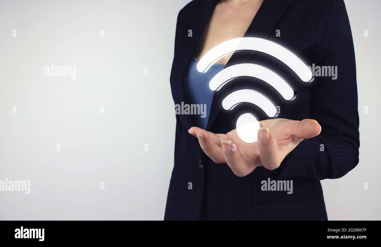 Business Networking Verbindungskonzept und Wi-Fi Konzept. Hand halten digitales Hologramm WIFI-Symbol auf grauem Hintergrund Stockfoto