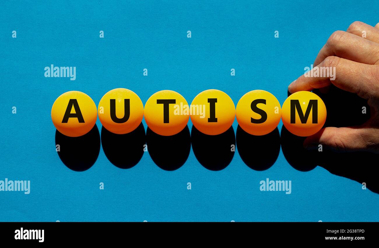 Symbol für Medizin und Autismus. Das Konzeptwort „Autismus“ auf orangefarbenen Tischtennisbällen auf einem schönen blauen Hintergrund. Arztzand. Medizinisch, psychologisch Stockfoto
