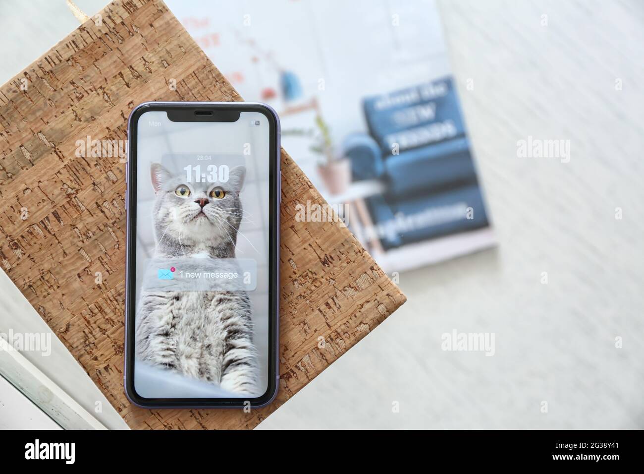 Mobiltelefon mit E-Mail-Benachrichtigung auf dem Bildschirm und Notebook auf dem Tisch Stockfoto