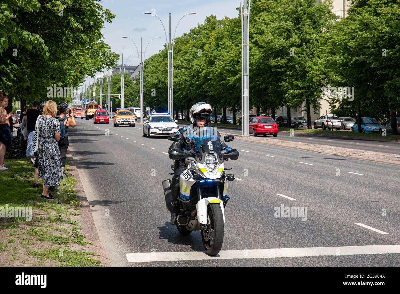 Polizeibeamter mit Motorrad macht den Weg frei für die Parade zum 160. Jahrestag der Rettung der Stadt Helsinki in Munkkiniemi, Helsinki, Finnland Stockfoto