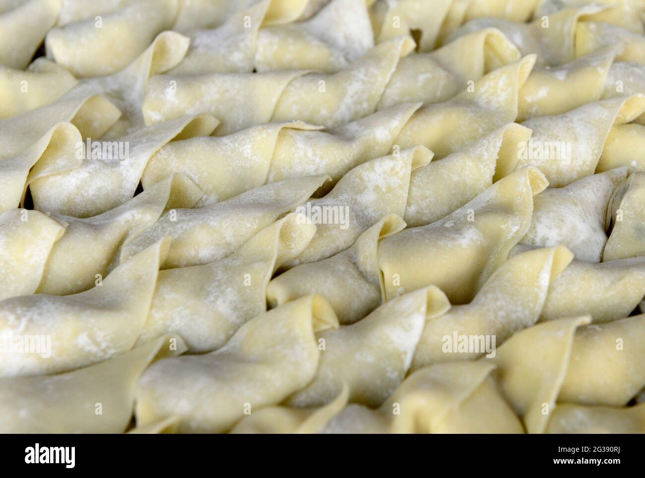 In einem Restaurant in Qingdao, China, warten viele wohlgeformte und gerade gemachte Knödel auf den Kochtopf Stockfoto