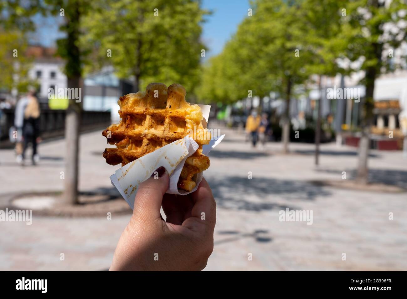 Essen von frisch gebackenen heißen belgischen Zuckerwaffeln, Street Food in Brügge Stockfoto