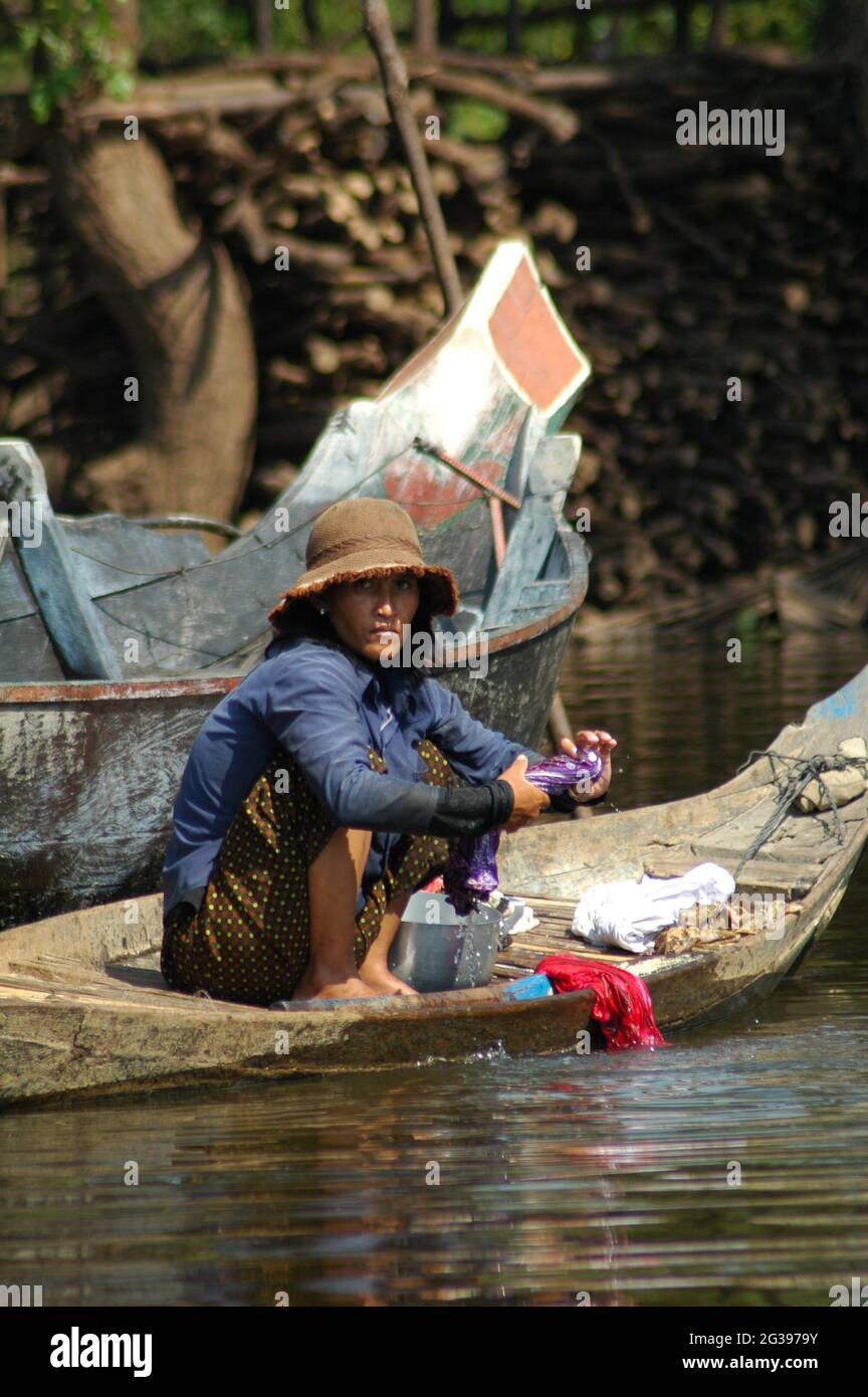 Eine kambodschanische Frau, die im schwimmenden Dorf im überschwemmten Wald von Kompong Phhluk in Siem Reap, Kambodscha, Kleidung von einem Schlauchboot wäscht. 27. Dezember 2006. Stockfoto