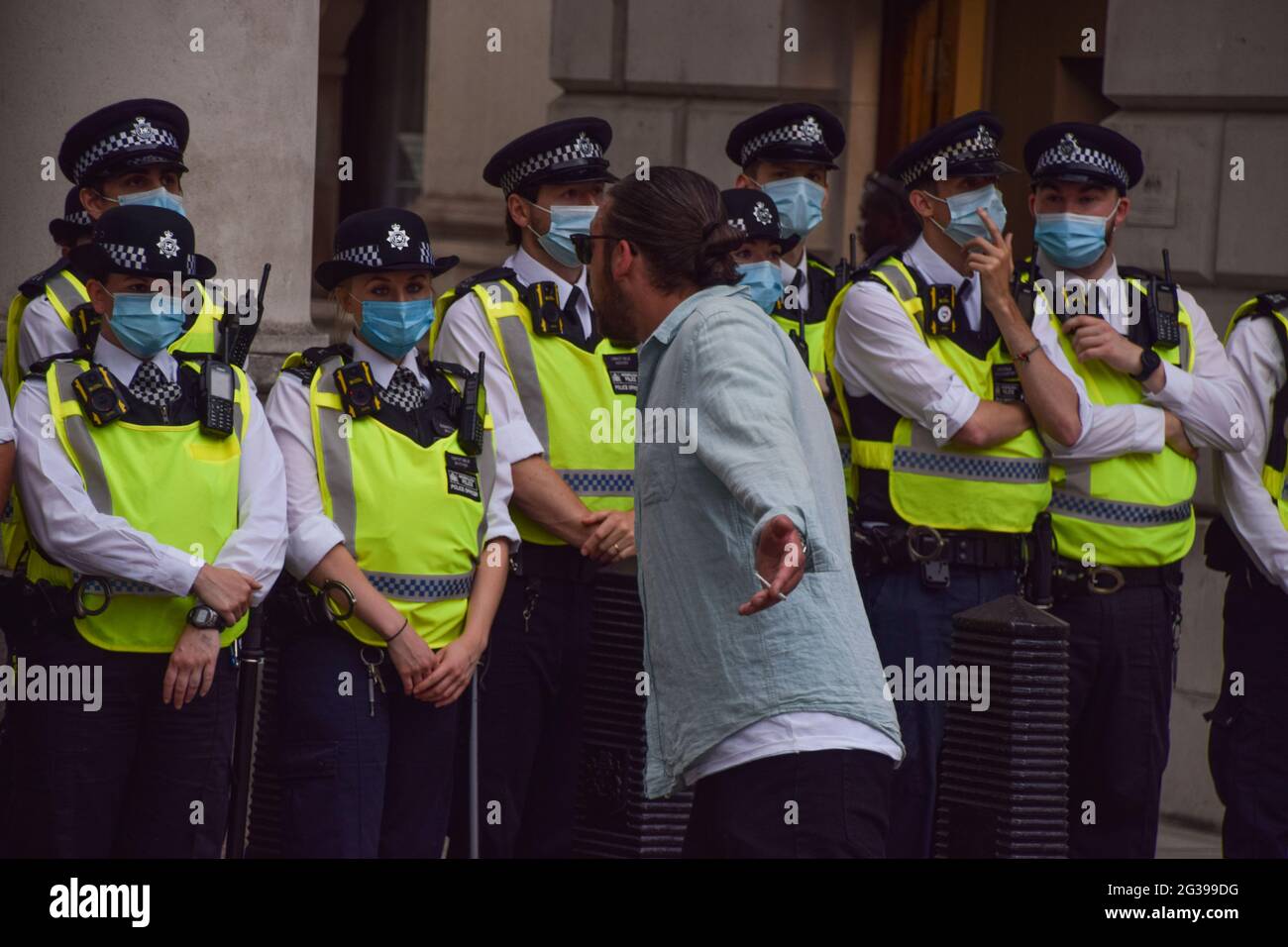 London, Großbritannien. Juni 2021. Ein Protestler verhöhnt die Polizei in Whitehall. Anti-Sperren-, Anti-Impfstoff- und Anti-Maske-Demonstranten versammelten sich vor den Houses of Parliament und Downing Street, als die Regierung ankündigte, dass die Aufhebung weiterer COVID-19-Beschränkungen bis zum 19. Juli verschoben wird. (Kredit: Vuk Valcic / Alamy Live News). Stockfoto