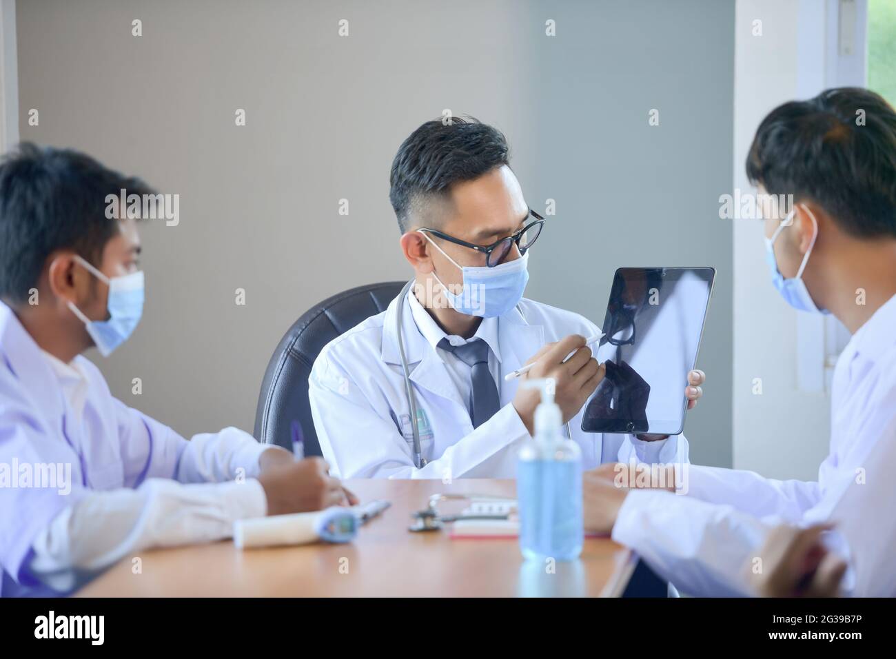 Gruppe von Ärzten, die die Arbeit im Bürokrankenhaus besprechen Stockfoto