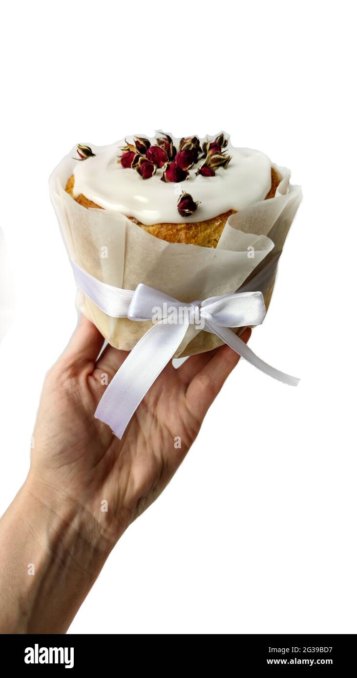 Handgehaltener Panettone mit Rosen, Papier und Schleife Stockfoto