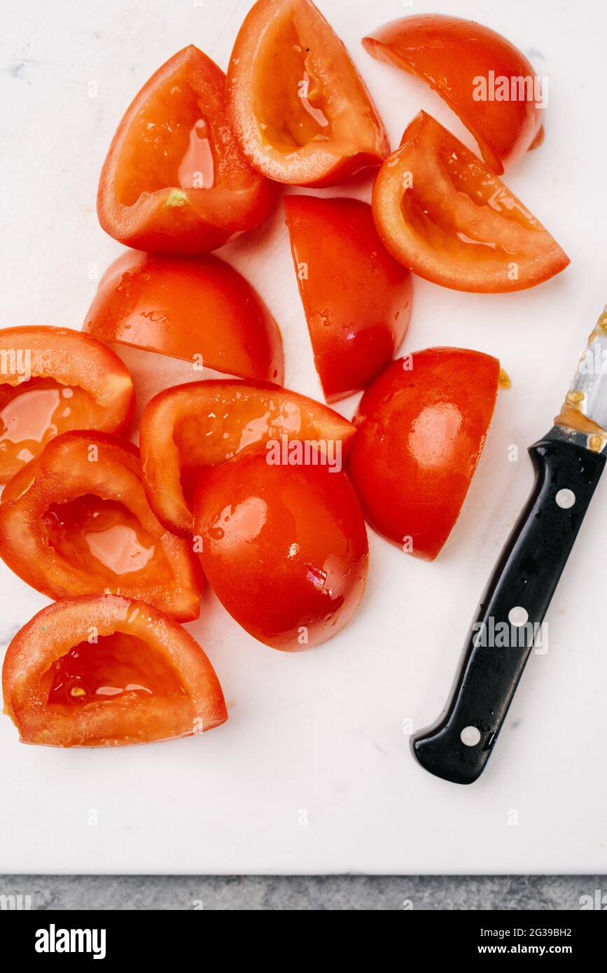 Frische, von Weinreben gereifte Tomaten auf einem Schneidebrett Stockfoto