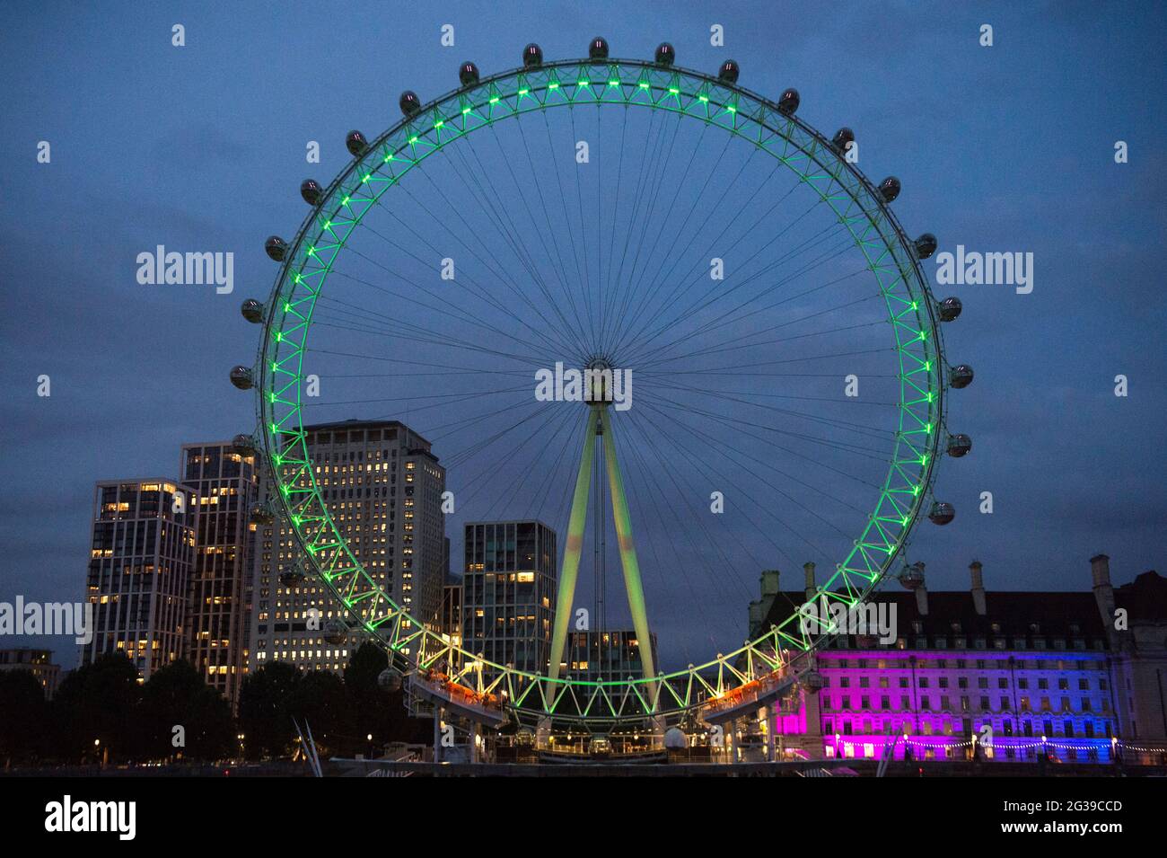 Das London Eye in Westminster, London, wird grün beleuchtet, um an die 72 Toten und alle, die von der Tragödie des Brandes im Grenfell Tower von 2017 betroffen waren, zu erinnern. Bilddatum: Montag, 14. Juni 2021. Stockfoto