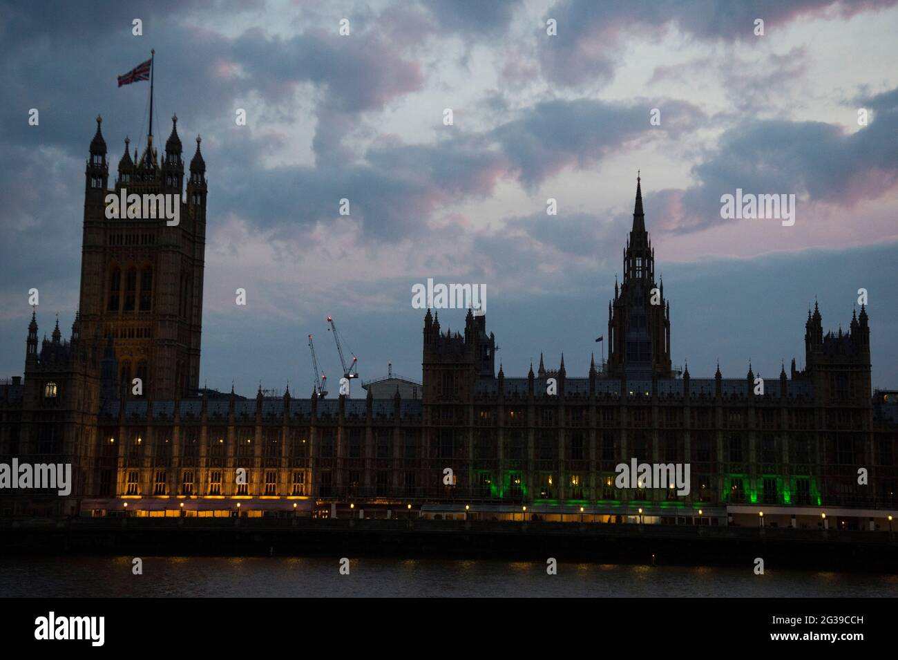 Der Palast von Westminster in London wird grün beleuchtet, um an die 72 Toten und alle Betroffenen des Feuers im Grenfell Tower von 2017 zu erinnern. Bilddatum: Montag, 14. Juni 2021. Stockfoto