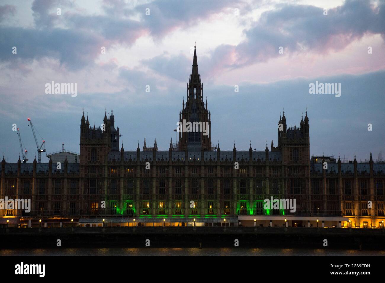 Der Palast von Westminster in London wird grün beleuchtet, um an die 72 Toten und alle Betroffenen des Feuers im Grenfell Tower von 2017 zu erinnern. Bilddatum: Montag, 14. Juni 2021. Stockfoto