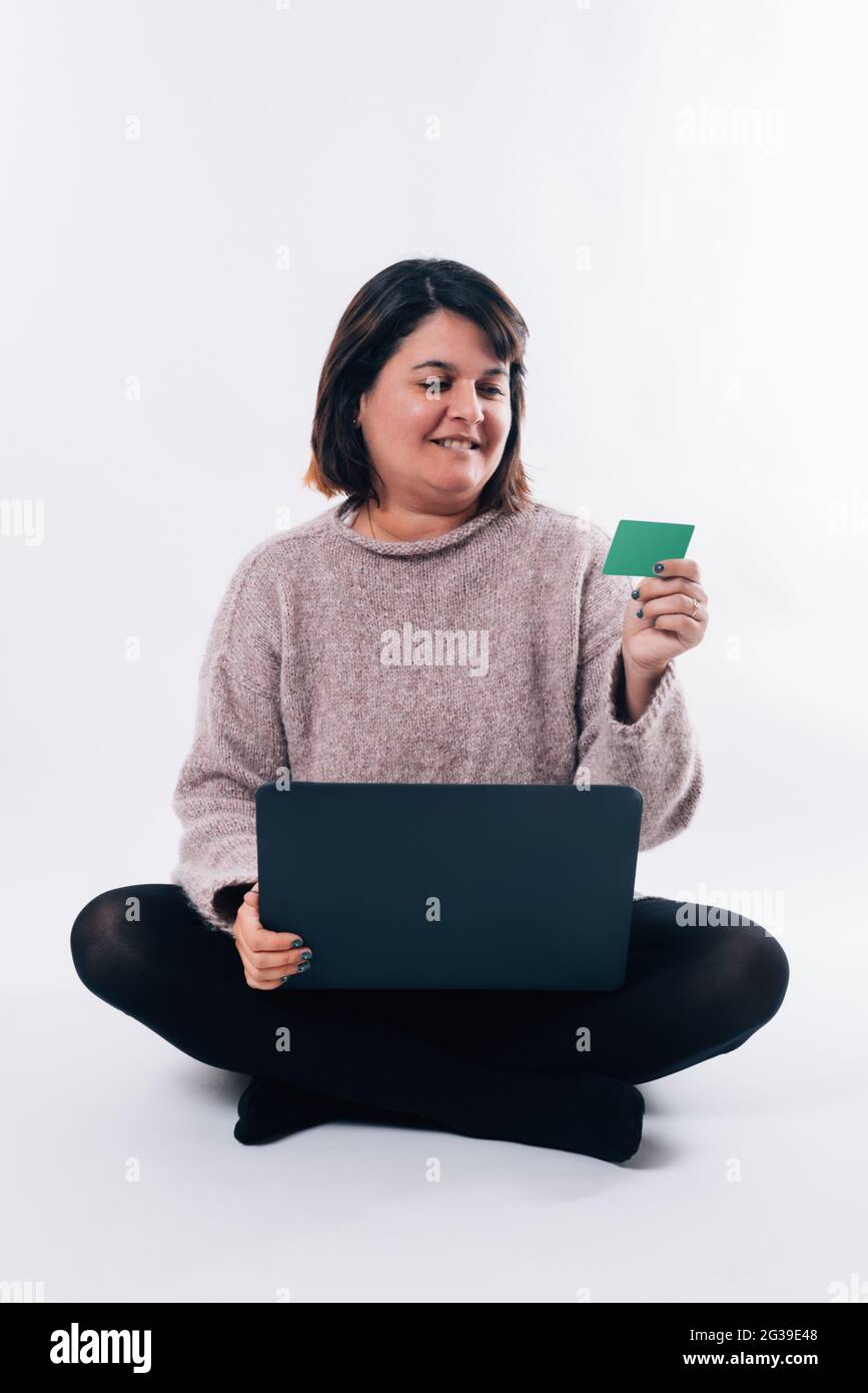 Vertikales Bild einer Frau, die auf eine Kreditkarte schaut und einen PC benutzt. Internet-Shopping-Konzept Stockfoto