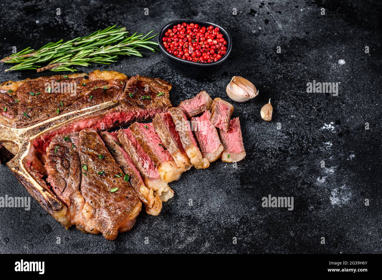 Gegrilltes italienisches Florentiner oder Rindersteak mit Knochen. Schwarzer Hintergrund. Draufsicht. Speicherplatz kopieren Stockfoto