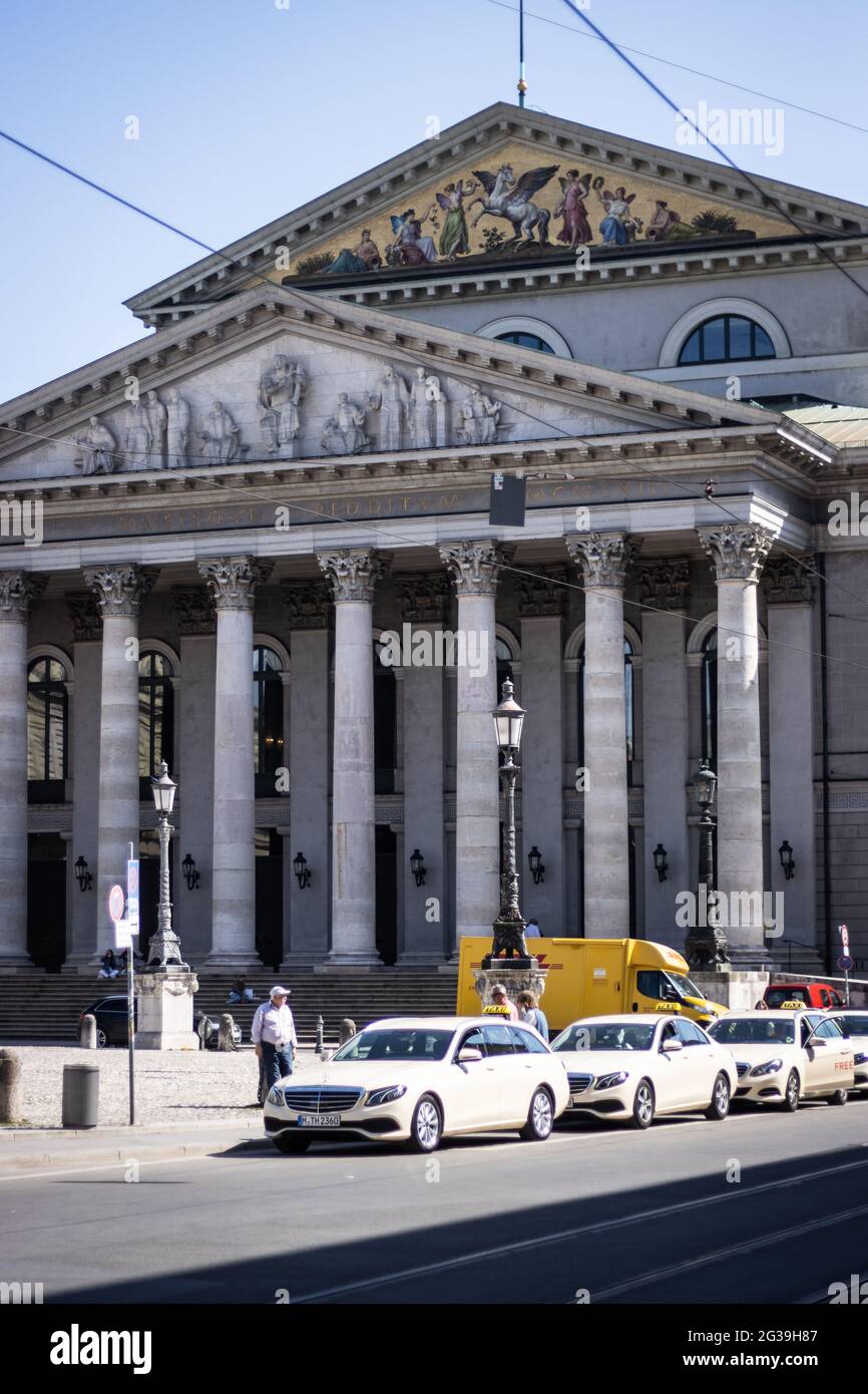MÜNCHEN, DEUTSCHLAND - 12. Jun 2021: Taxis parken vor der Oper in München, Wahrzeichen Stockfoto
