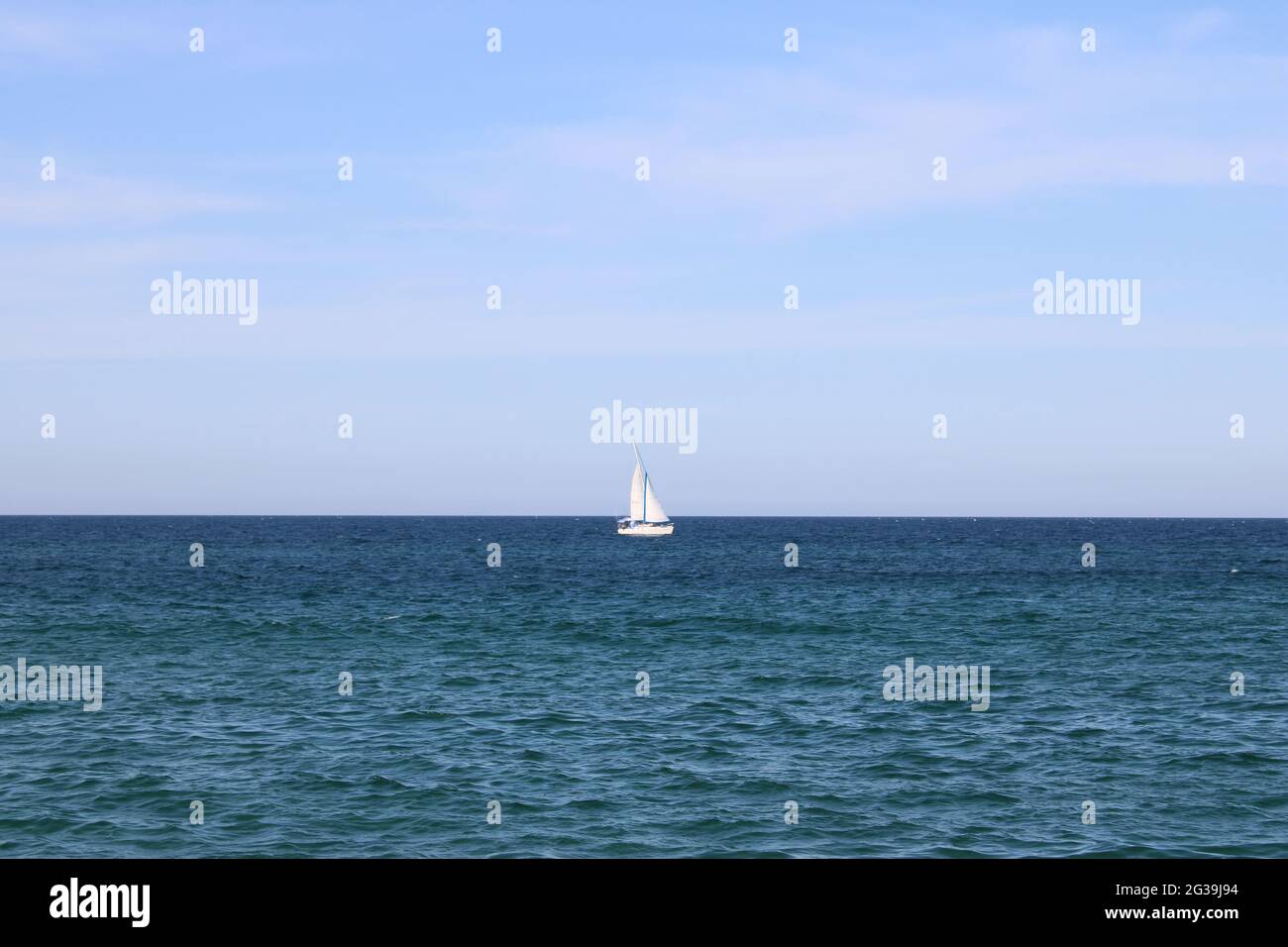 Eineres weißes Segelboot auf offenem Meer Stockfoto