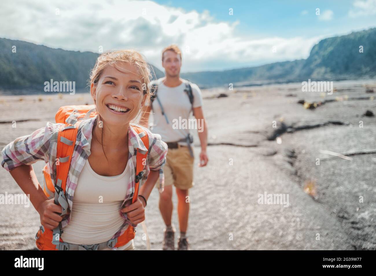 Wandern Paar Wandern mit Rucksäcken auf Lavafeld Trail in Hawaii. Sommer reisen glücklich lächelnd asiatische Mädchen und Mann Wanderer Outdoor-Abenteuer auf Big Stockfoto