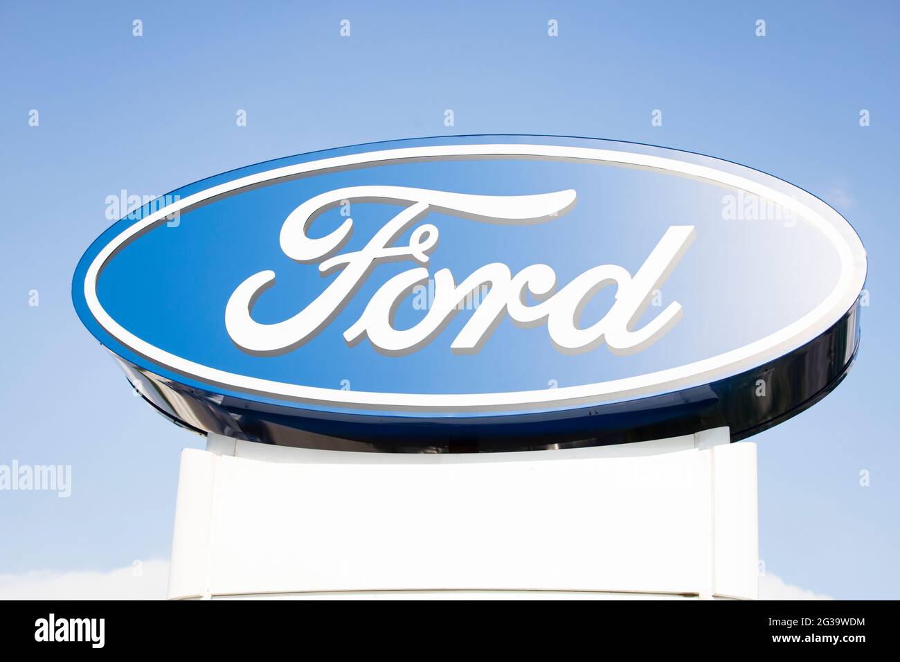 Das Ford-Logo ist auf einer Plakatwand vor einem blauen Himmel Hintergrund. Stockfoto