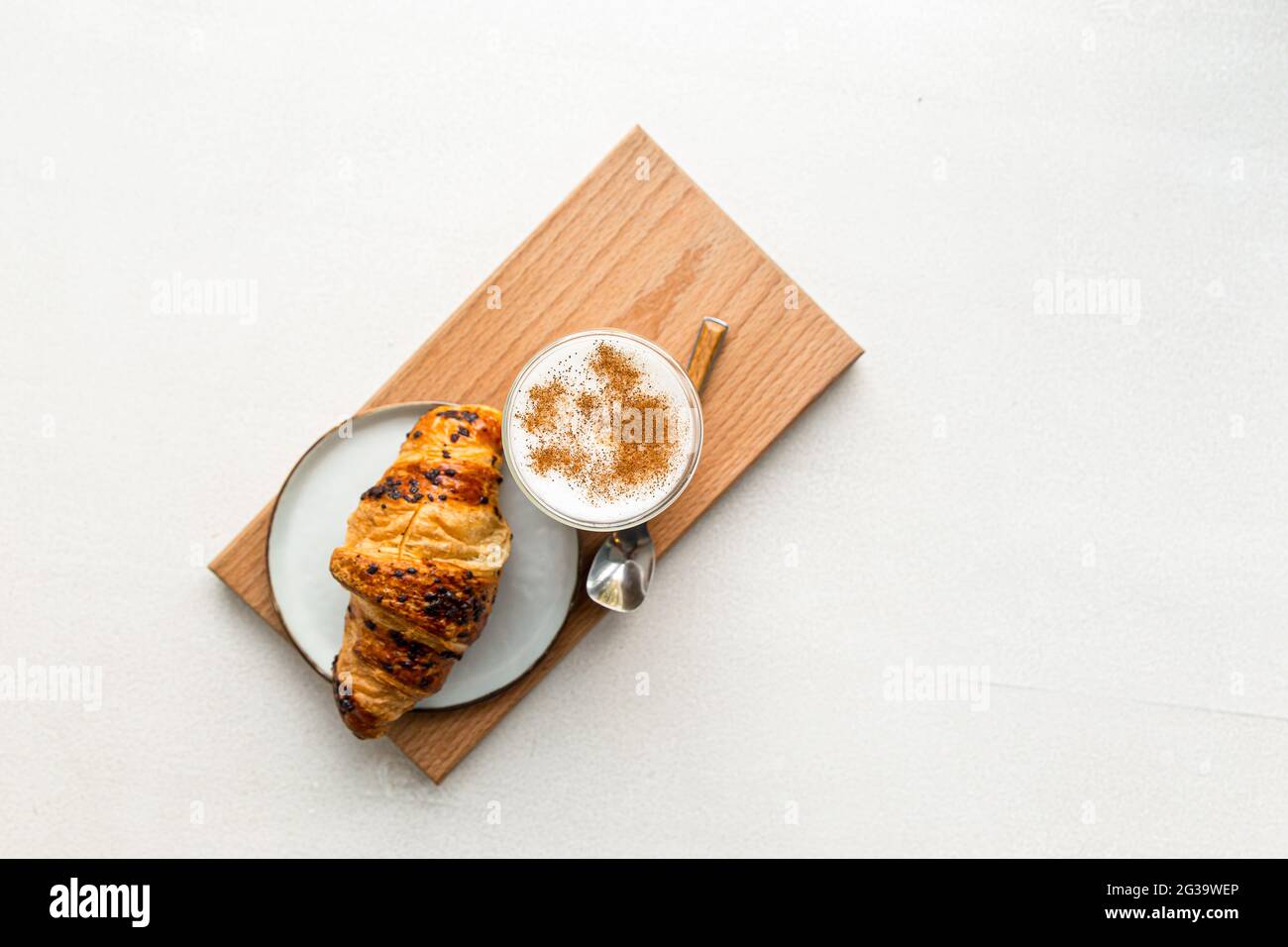 Glas Kaffee Latte mit Zimt und Croissant Stockfoto