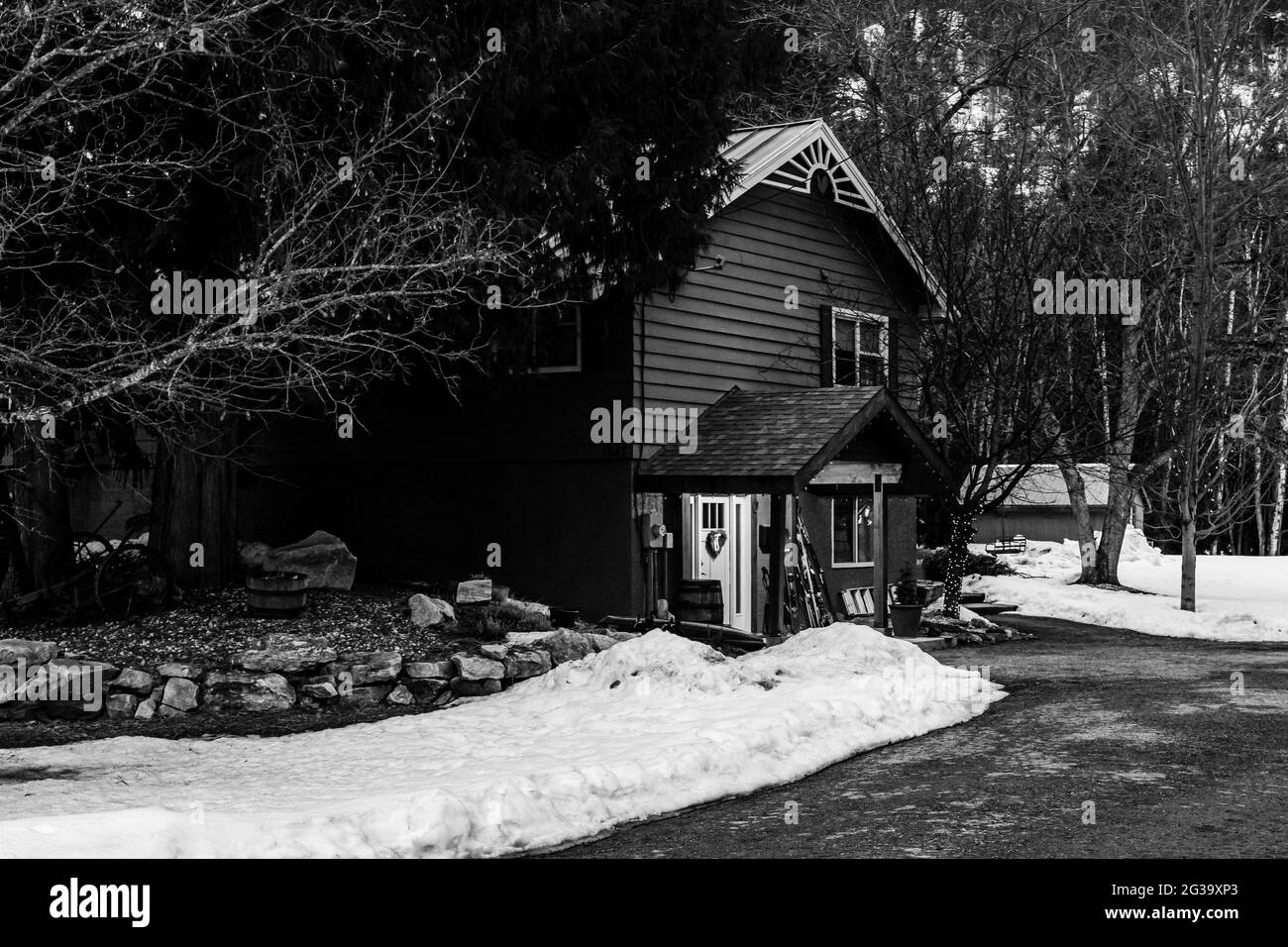 REVELSTOKE, KANADA - 14. MÄRZ 2021: Schwarz-weißes Privathaus in Kleinstadt Abendzeit früher Frühling mit Schnee Stockfoto