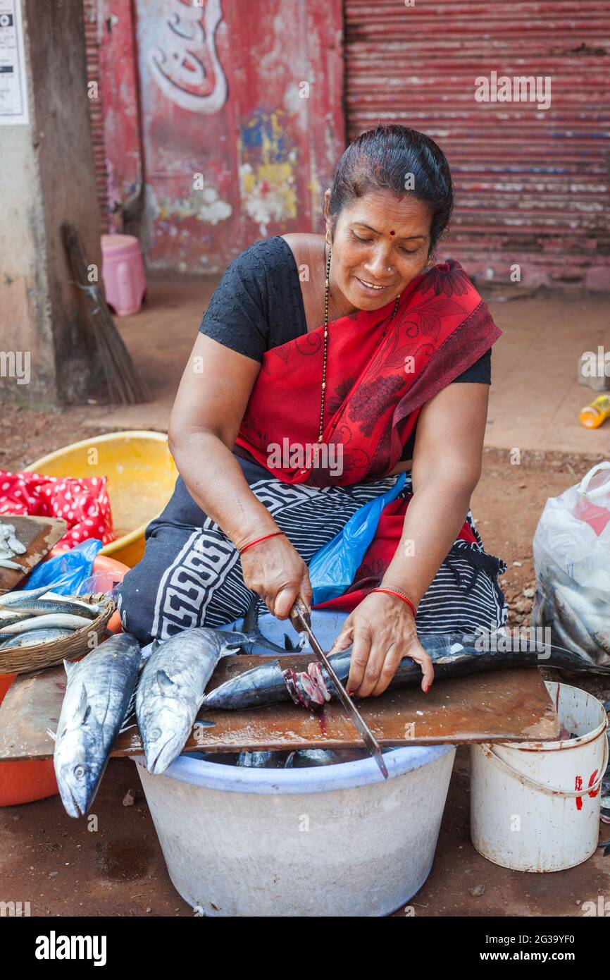 Indische Fischerin, die große Fische mit großem Messer auf dem Marktplatz, Agonda, Goa, Indien, schneidet Stockfoto