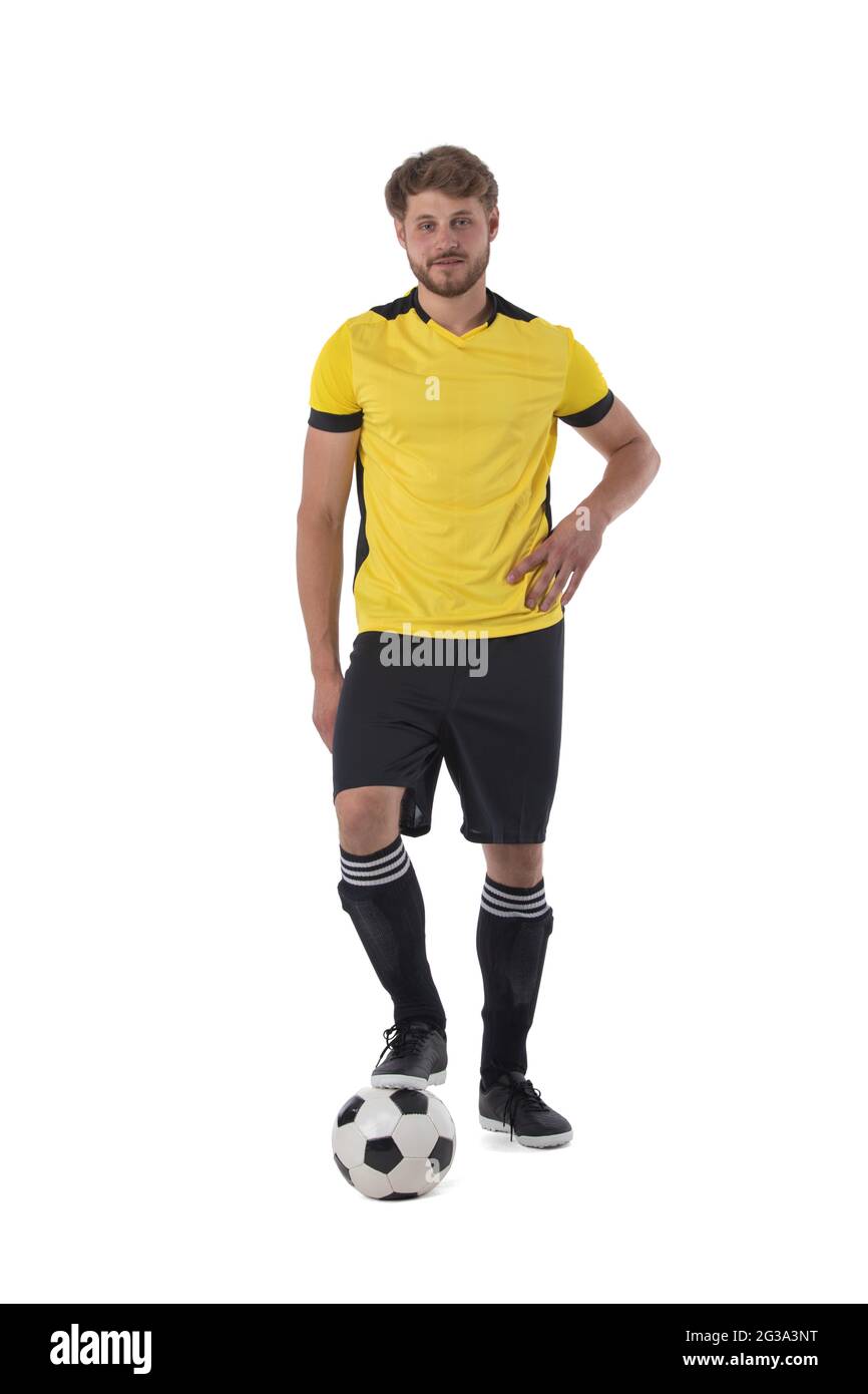 Fußballspieler, der mit einem Fuß auf einem Ball auf weißem Hintergrund steht Stockfoto