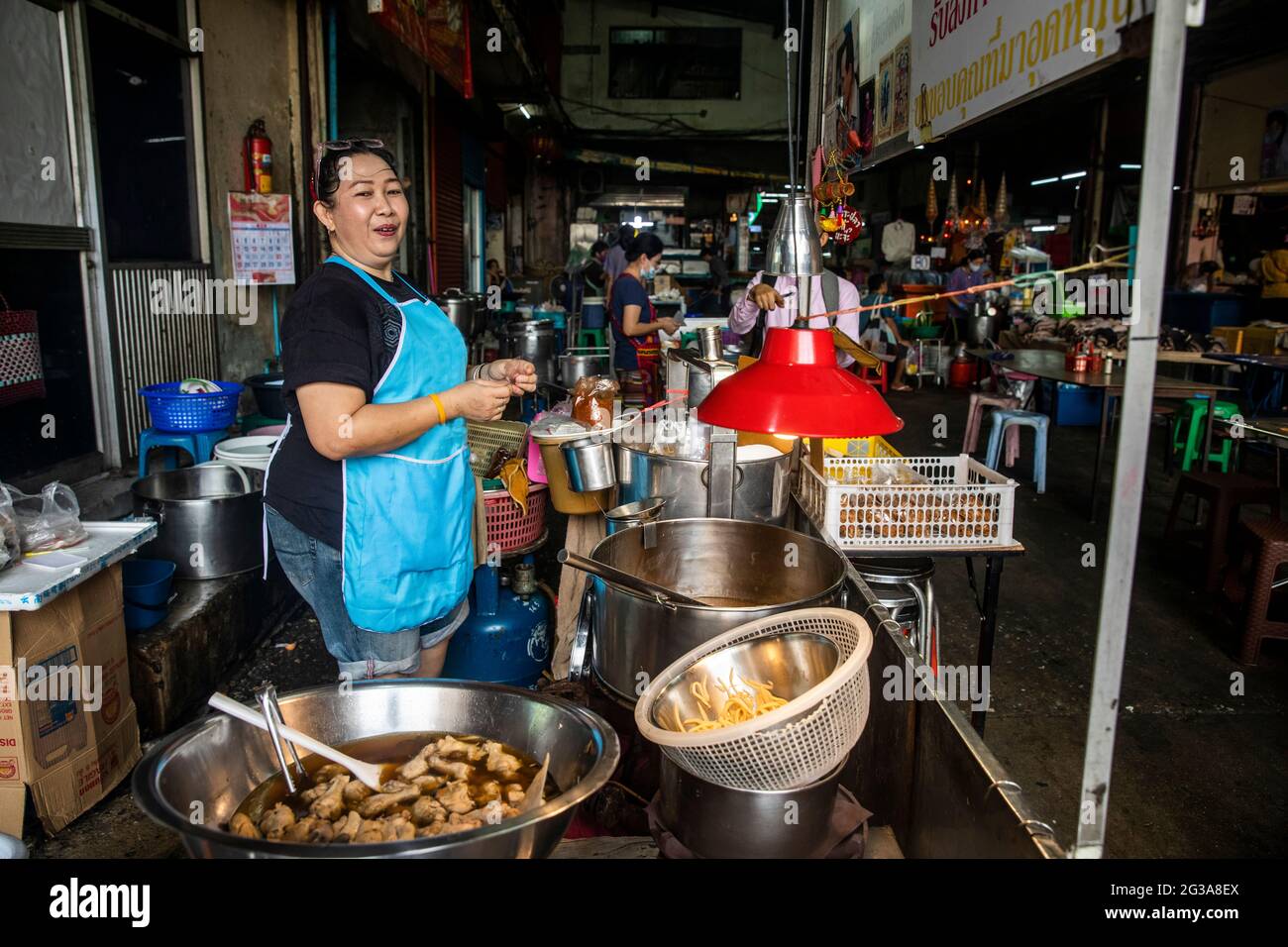 Ein erfahrener Koch- und Gastronomieteur hat eine Vielzahl von Suppen und anderen Vorspeisen für Kunden auf dem Bang Rak Wet Market in Bangkok. Stockfoto