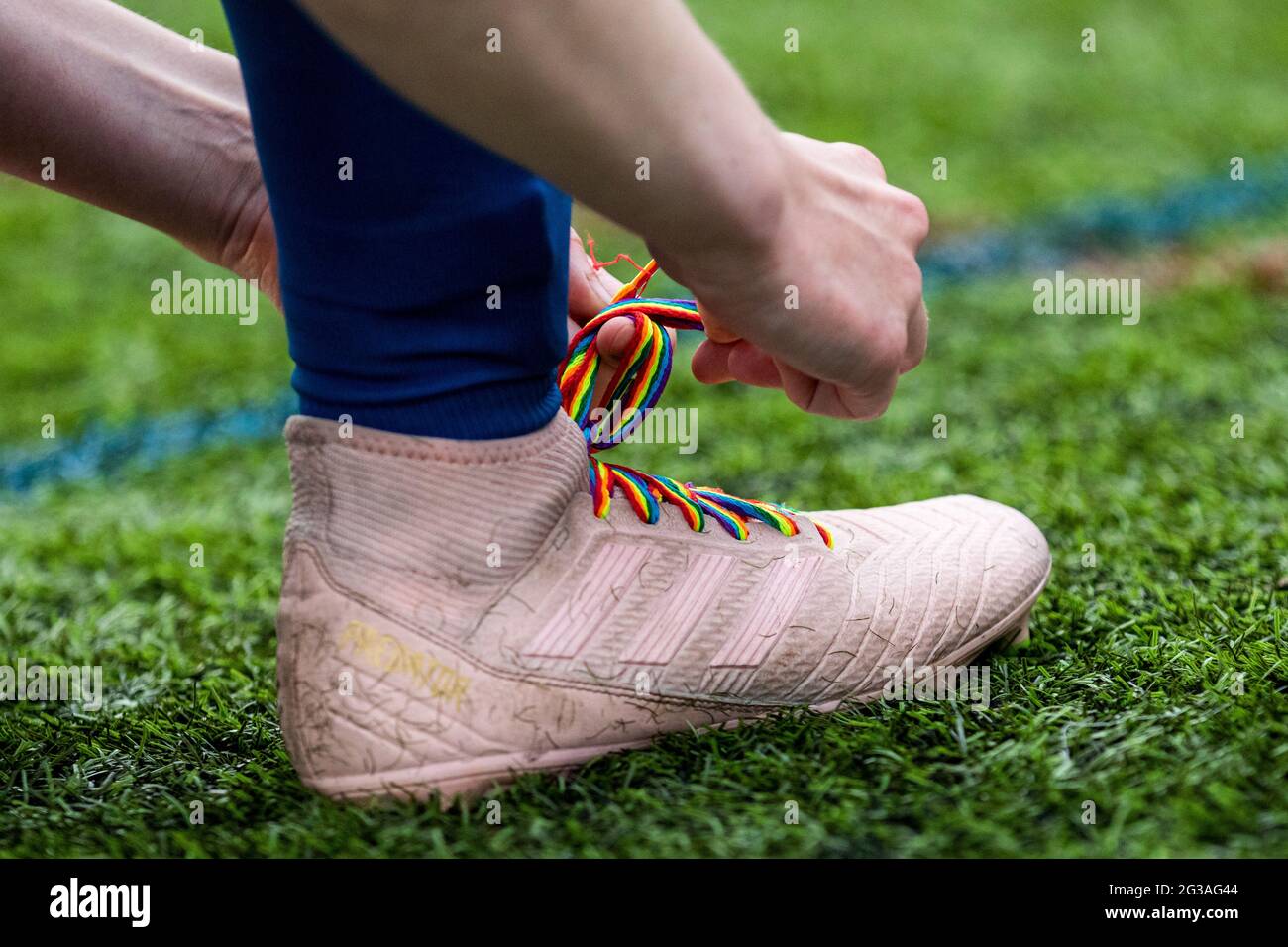 Ein Fußballer schnürt Stonewall's Rainbow Laces auf einem Adidas Predator Fußballschuh. Stockfoto