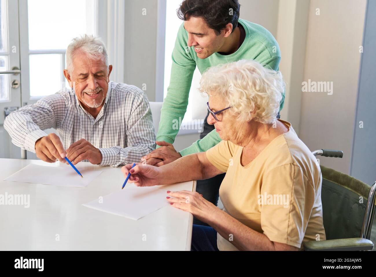 Senioren, die mit Hilfe ihres Sohnes Verträge oder Testamente zu Hause ausfüllen Stockfoto
