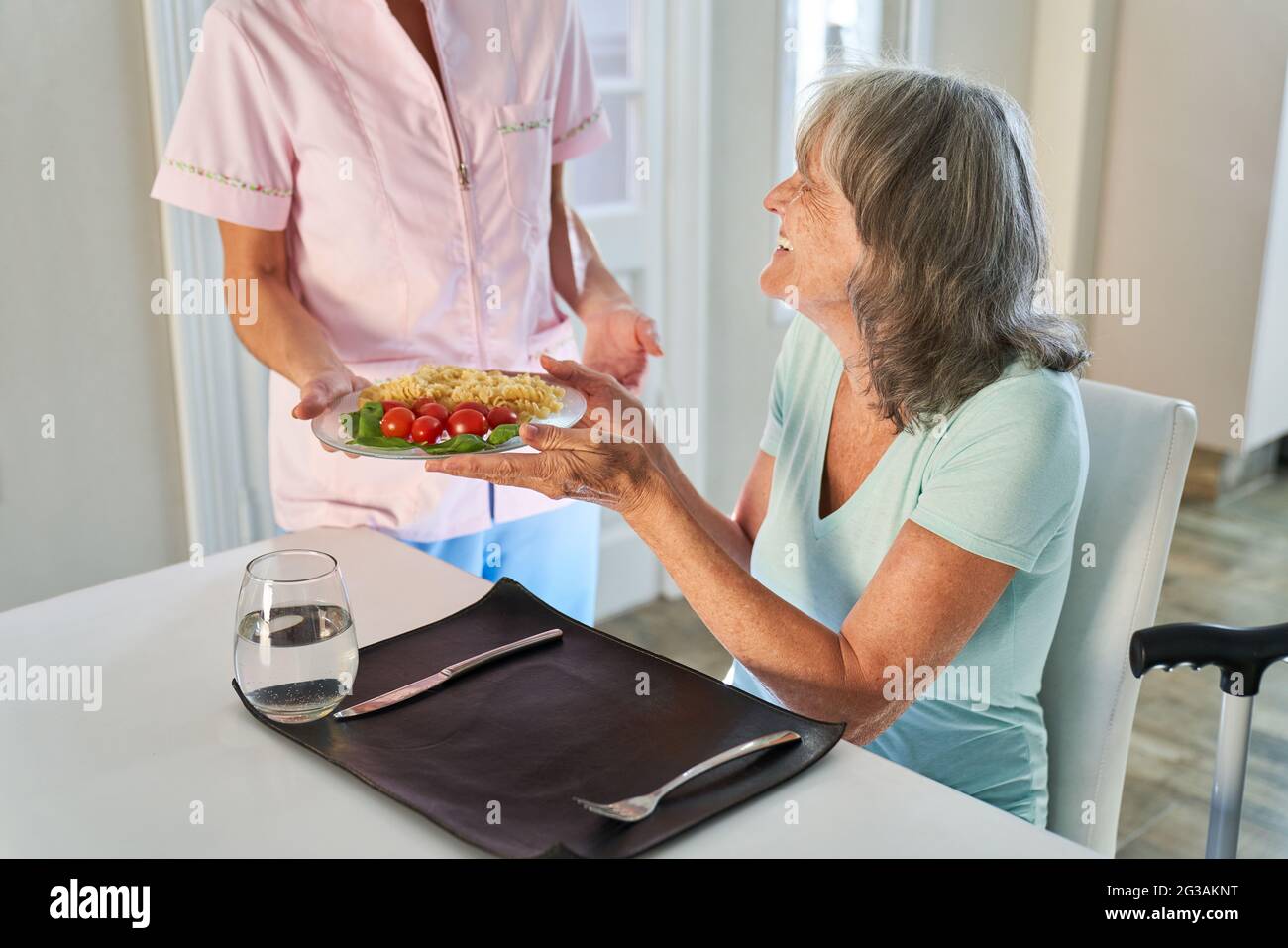 Dankbare ältere Frau genießt das Mittagessen vom Lieferservice in ihrer Wohnung zu Hause Stockfoto
