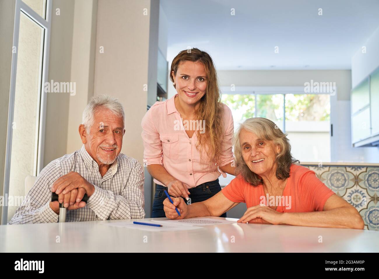 Tochter hilft Eltern Rätsel zu lösen, wie Gedächtnistraining und Gehirnteaser am Tisch zu Hause Stockfoto