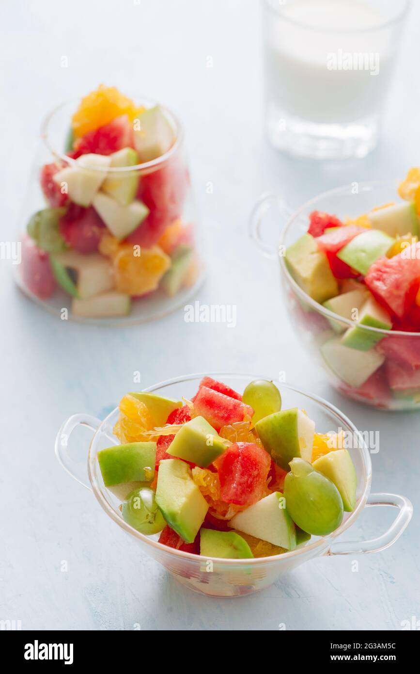 Stücke von tropischen Früchten in einem Glas. In Scheiben geschnittene Orange, Apfel, Scheiben Wassermelone in Glasschale. Zitrusfrüchte Stockfoto