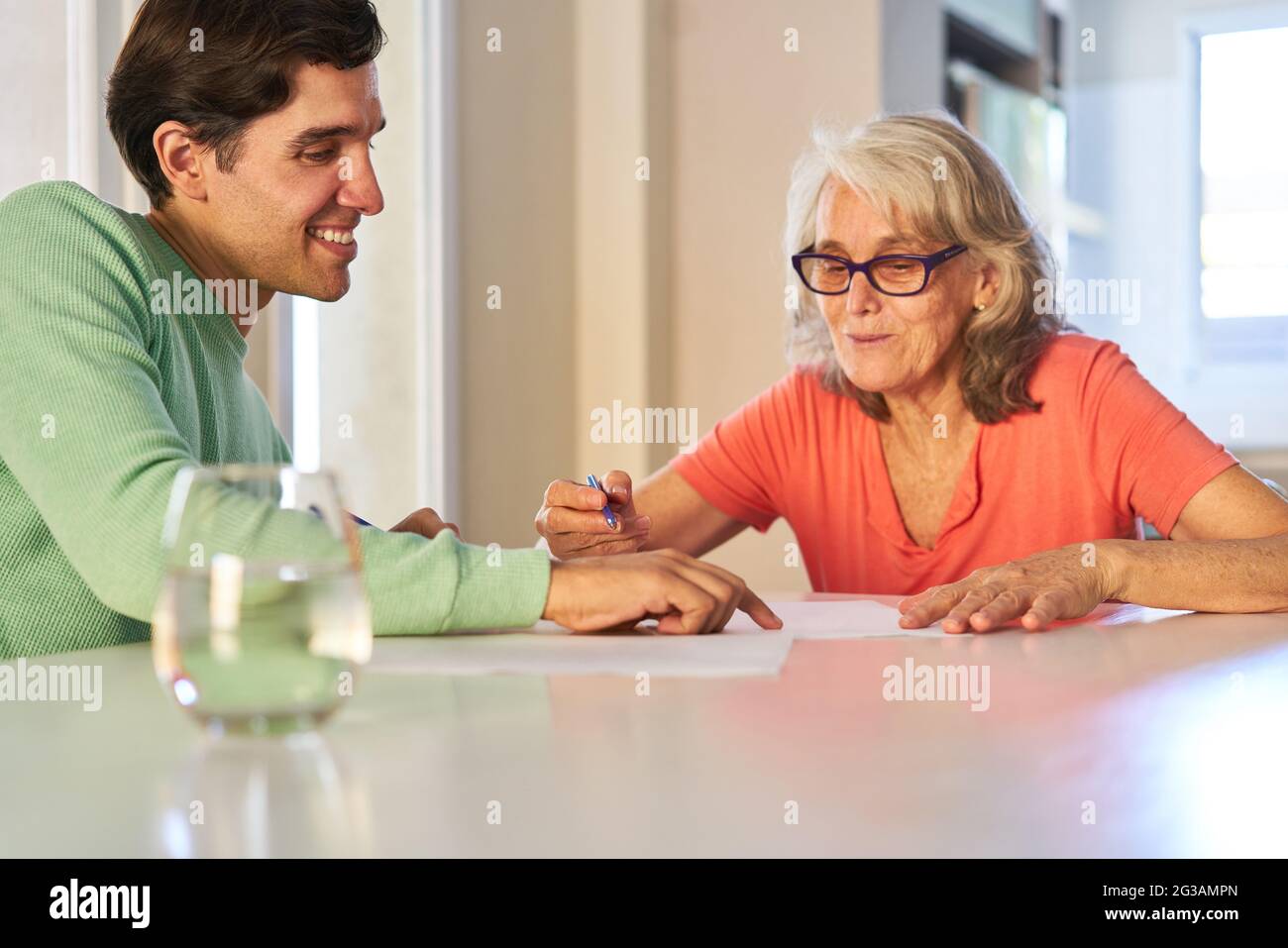 Ältere Frauen erhalten zu Hause von ihrem Sohn Rat zu Vertrag oder Versicherung Stockfoto