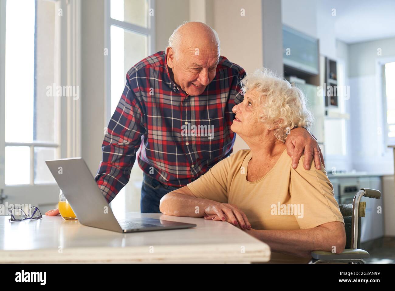 Glückliches Rentnerpaar, das zu Hause oder zu Hause einen Laptop benutzt Stockfoto