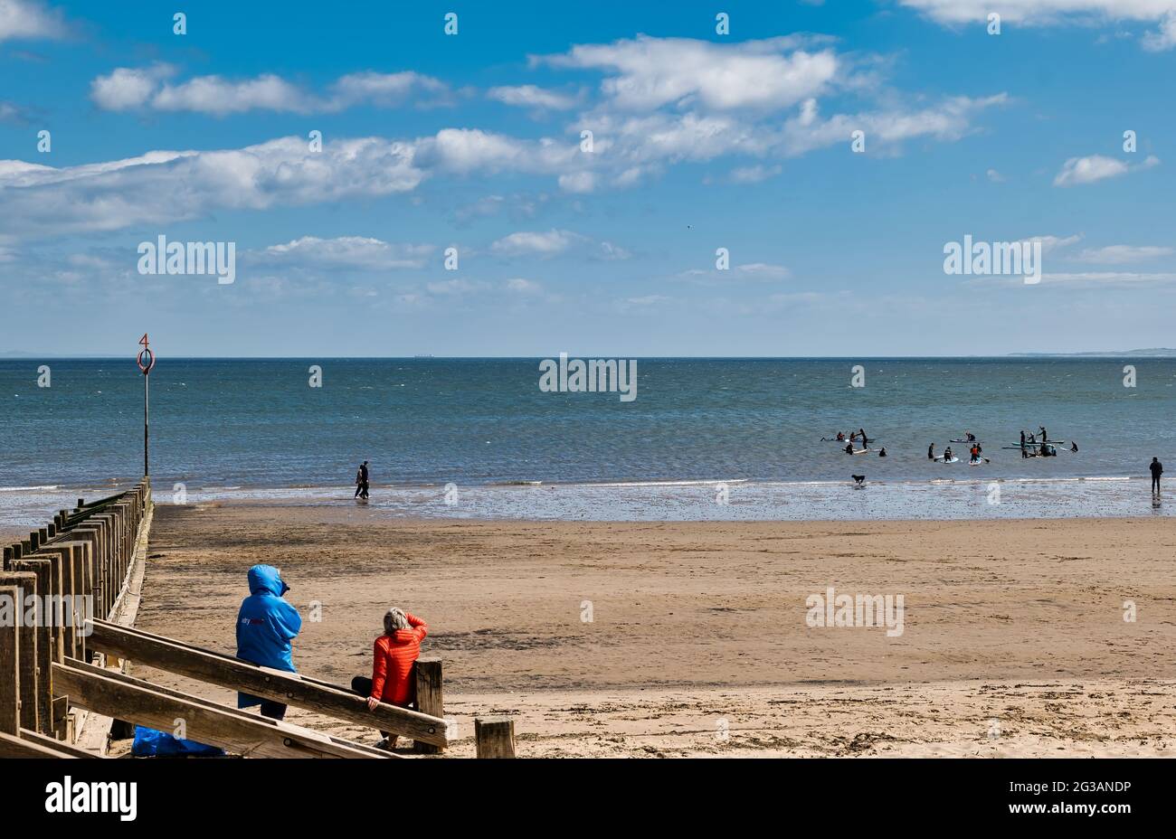 Paddelboarder gehen am Sommertag in Edinburgh, Schottland, Großbritannien, in den Firth of Forth Sea am Portobello Beach Stockfoto