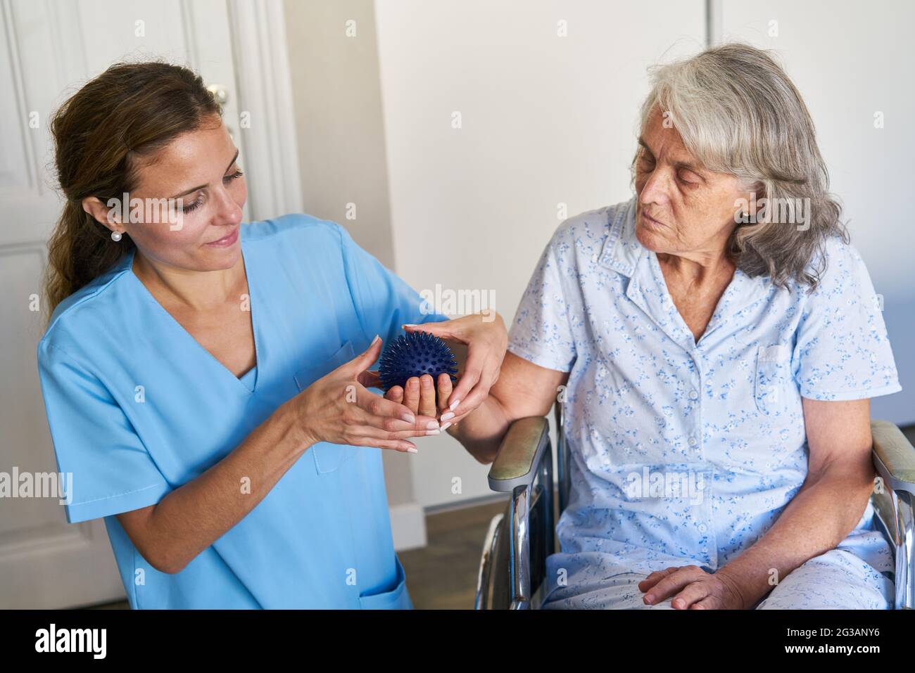 Ältere Frau im Rollstuhl während der Physiotherapie nach einem Schlaganfall im Pflegeheim Stockfoto