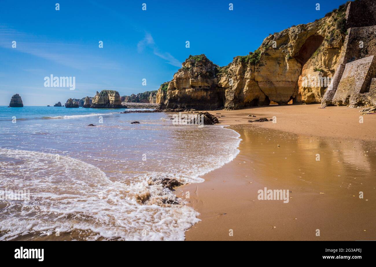 Klippen von Praia da Dona Ana, Sandstrand mit klarem blauen Wasser an einem sonnigen Tag, keine Menschen, Lagos, Algarve, Portugal Stockfoto