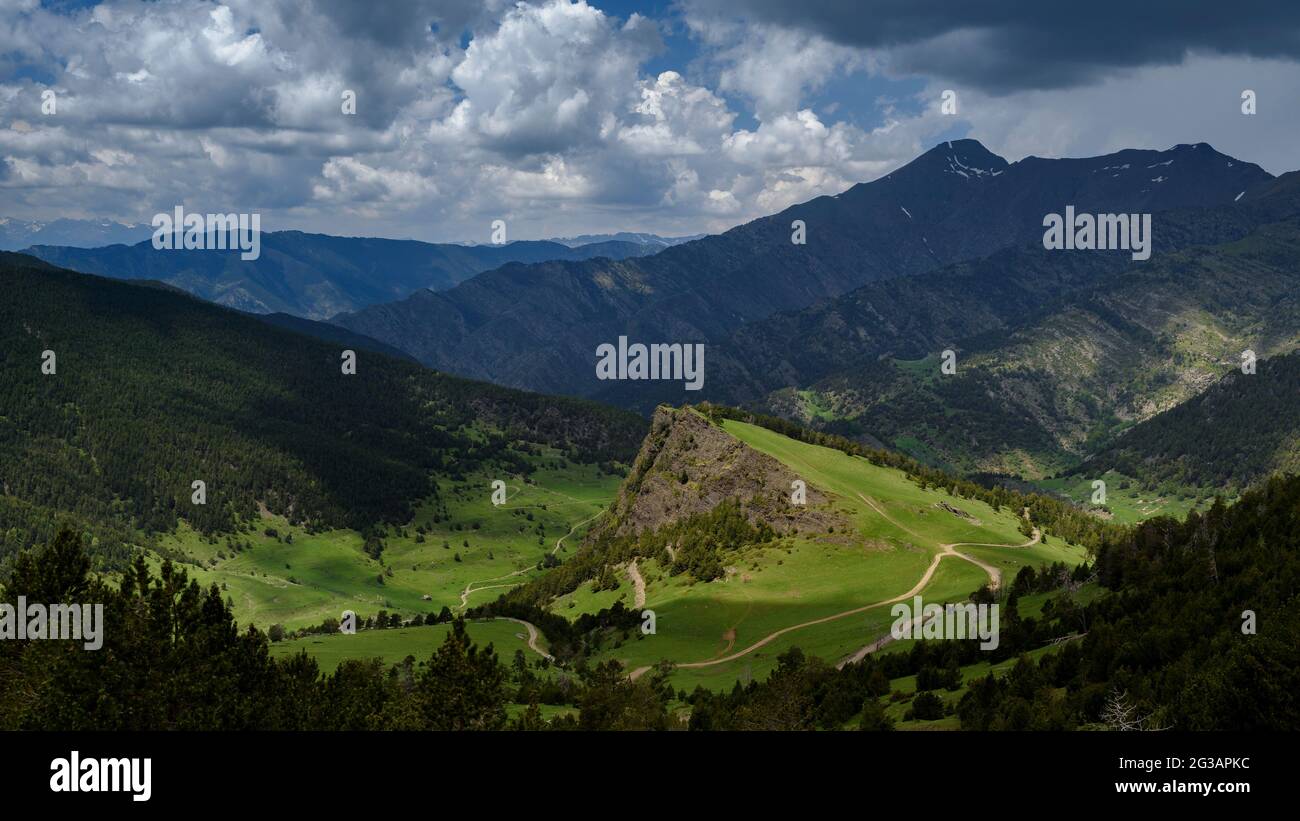 Tal von Tor von der Straße nach Andorra durch den Hafen von Cabús gesehen. Im Vordergrund der Roc de Llumeneres und grüne Wiesen im Frühjahr (Pyrenäen) Stockfoto