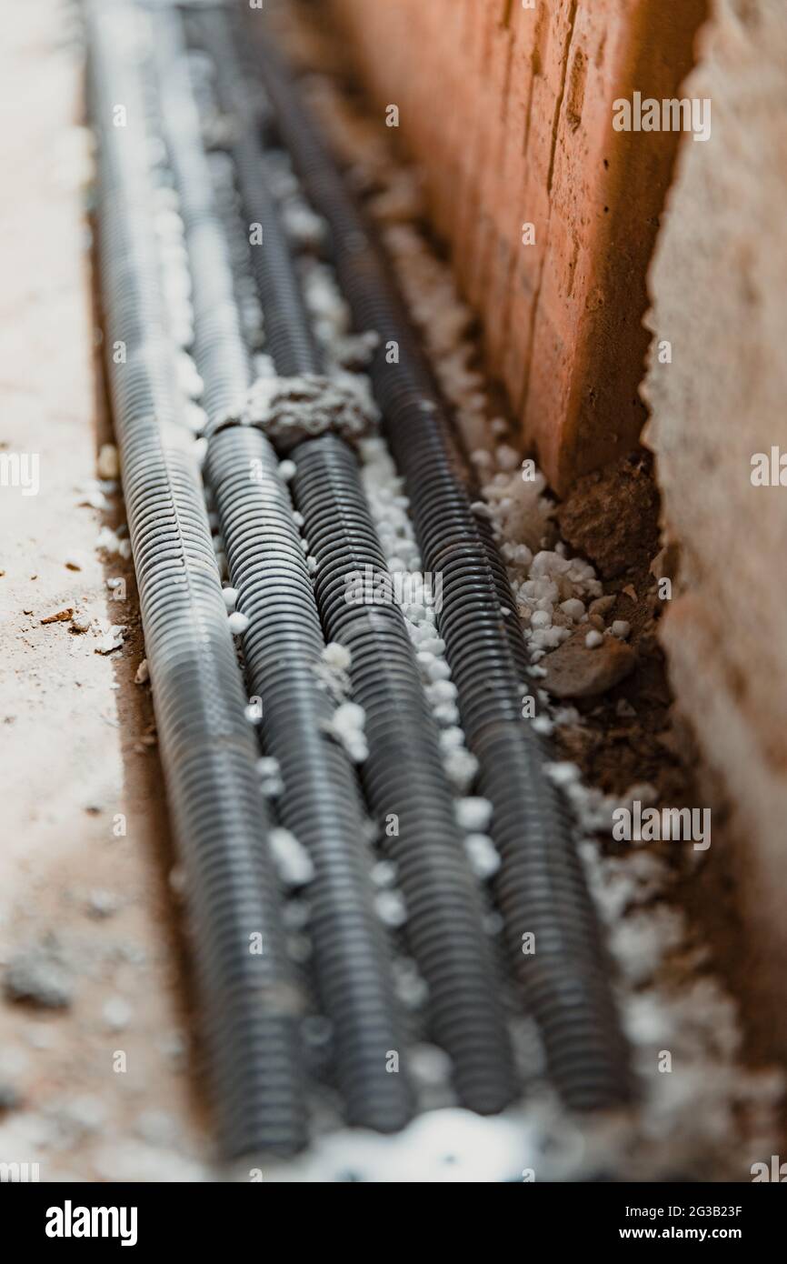 Vertikale Aufnahme von vier schwarzen Verstärkungen an der Wand Stockfoto