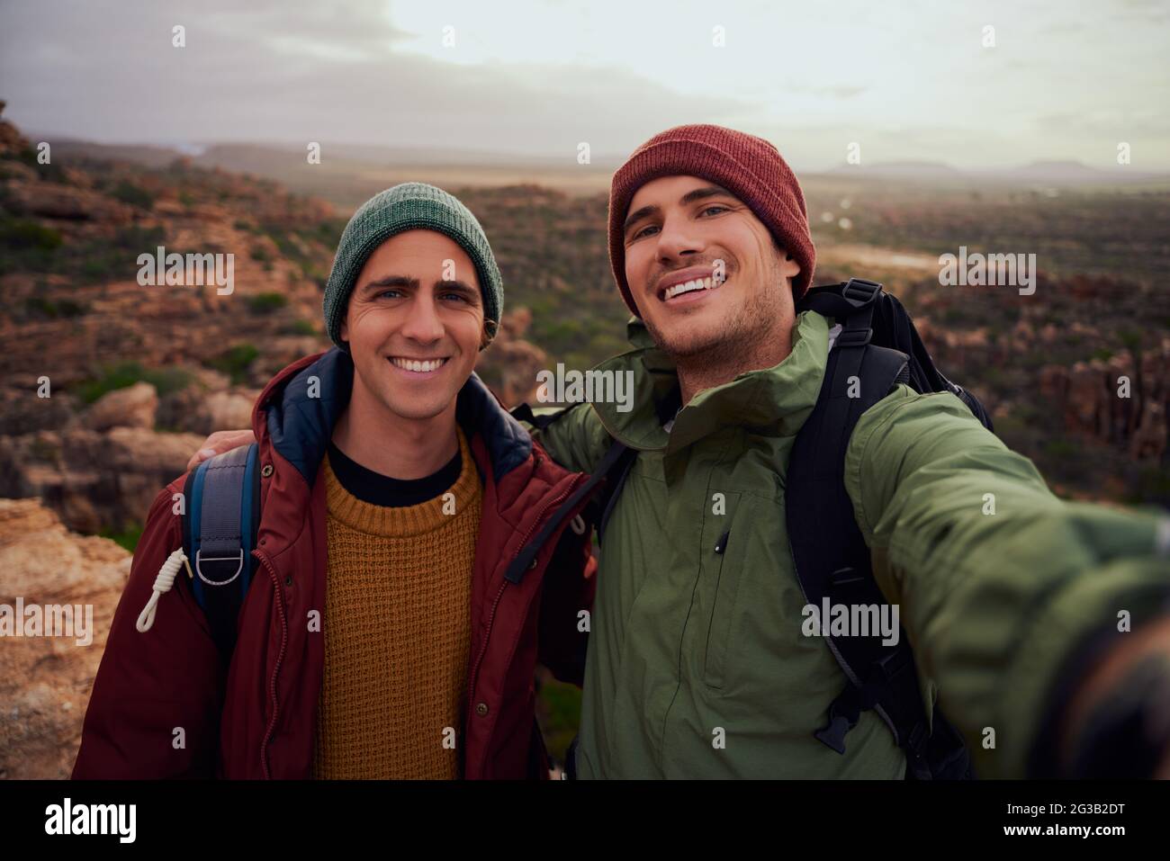 Portrait von gutaussehenden männlichen Freunden, die Selfie mit Rucksack machen, während sie den Berg besteigen Stockfoto