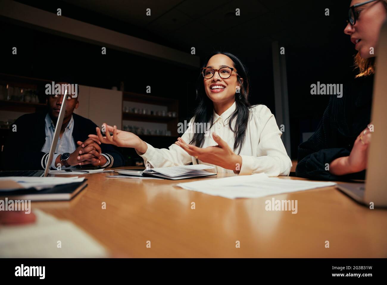 Porträt einer jungen lächelnden Geschäftsfrau, die mit seinem Kollegen im Gespräch ist Stockfoto