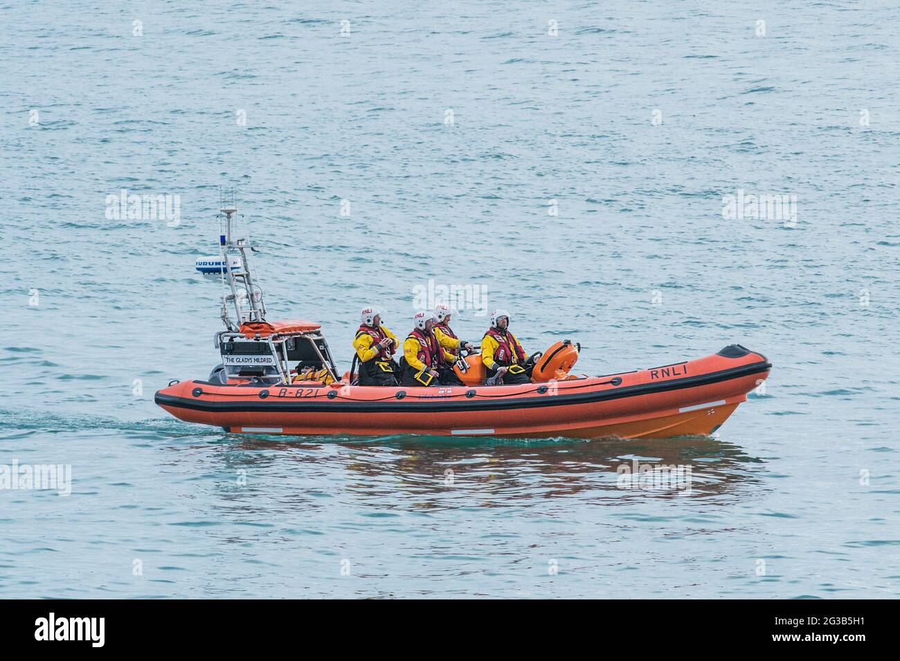 Die RNLI Gladys Mildred, das Rettungsboot Atlantic 85 von Newquay, reagiert auf eine Notrufnummer am Ende des Tages in der Fistral Bay in Cornwall. Stockfoto